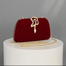 Red handbag with gold accents on a white pedestal against a gray background, featuring the brand 'Opulaura'.